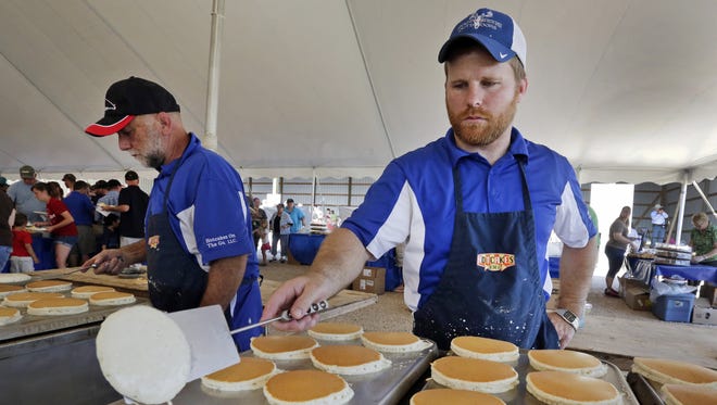 Joe Potter of Hartford, right, flips pancakes during Breakfast on The Farm at Majestic Crossing Dairy near Sheboygan Falls.