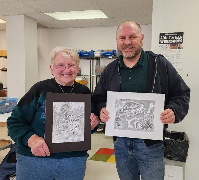 Susan and Russ display their favorite Suminagashi marbling creations they made during an art class at the Trout Museum in Appleton.