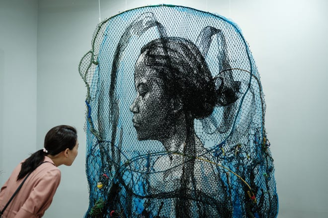 April 28, 2024 : A visitor looks at Indonesian artist Iwan Yusuf's artwork titled "Infinity" made of used and new fishing nets during the Jakarta Art Gardens art fair in Jakarta, Indonesia.