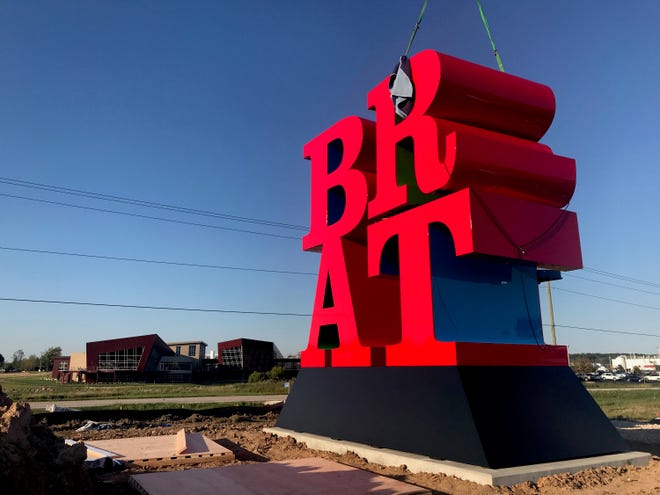 The letter R is lowered into place.  Johnsonville installed what's said to be one of Robert Indiana’s last pieces of art -- a sculpture spelling out the word BRAT -- at its headquarters in Sheboygan Falls on Tuesday, September 11, 2018. The tribute to bratwurst was commissioned by the owners of Johnsonville Sausage.