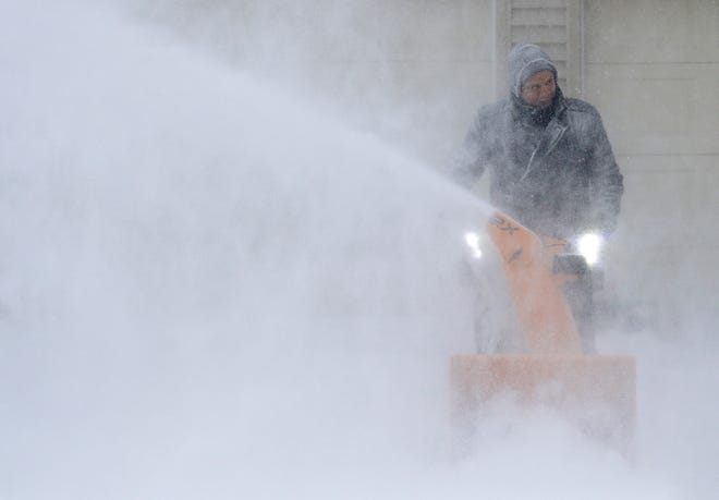 David Liebhard fights windy conditions as he snow blows his driveway during a snowstorm Monday, Jan. 28, 2019, in Appleton, Wis.