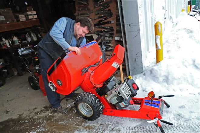 Fred Schmitter, a repair technician at Lorleberg True Value Hardware in Oconomowoc, searches for the source of the problem with a snowblower brought in for repair. The owner said it ran bad and had a bad smell, probably from a slipping drive belt of some sort.