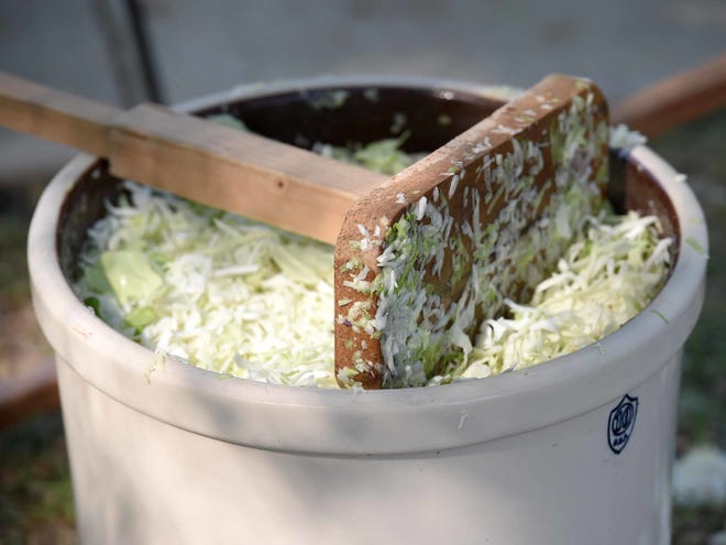 An implement used to pound shredded cabbage rests atop the large crock during the process to make sauerkraut at St. Joseph Catholic Church in Gluckstadt.