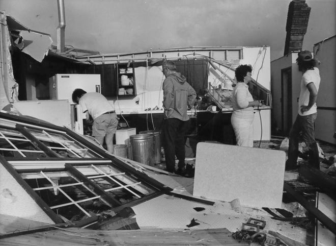 People visit their destroyed home after a tornado hit Barneveld in June 1984.