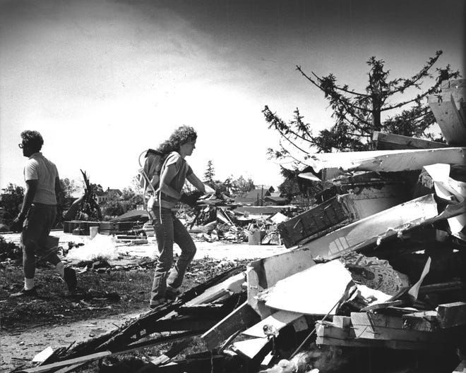Julie Belotti of Chicago carried her daughter, Rachel, on her back as she helped salvage items from her uncle ' s home in Barneveld after the June 8, 1984, tornado.