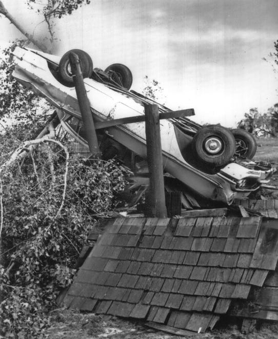 The Colfax tornado killed 21 people. 

An automobile lay propped up against a tree and the wrecked roof of a building.