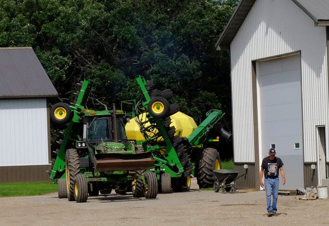 In this July 1, 2019, photo, Larry Ness puts spring planting equipment into storage at their farm near Comstock, Minn. The Ness family fears they will be forced to leave the farmstead where the family has lived since 1942.