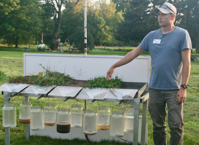 Using an NRCS rainfall simulator to demonstrate the effect of rainfall on different cropping systems, the runoff container below the conventionally planted field sample, third from left, produced the most runoff while soils from woodland, pasture and a former grass barnyard had minimal runoff.