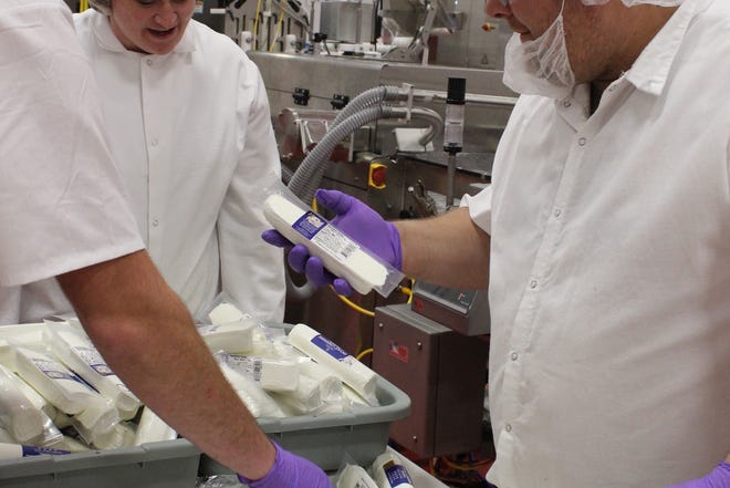 Cheesemaker Jennifer Kutz, center, talks to employees on the Chevre production line