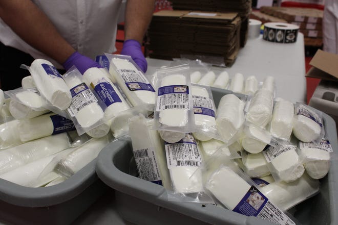 Employees inspect packages of Chevre cheese.