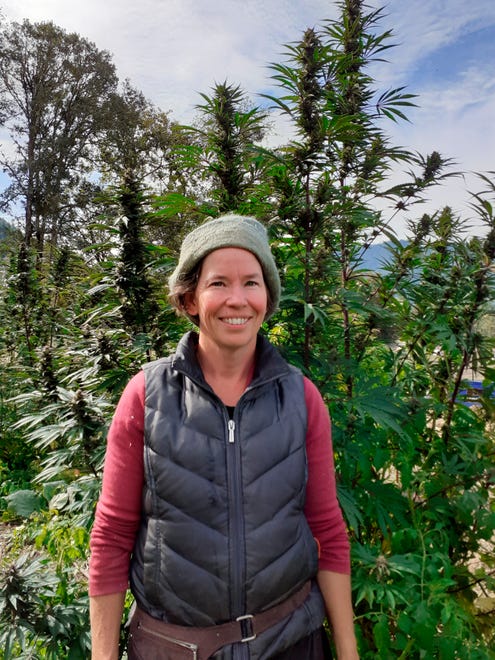In this undated photo provided by Rosales CBD, Dove Oldham poses in front of a hemp plant growing at Madrona Family Farm in Grants Pass, Oregon. Oldham, who sells hemp-derived CBD products under the name Rosales CBD, says she is concerned about federal rules regulating hemp farming recently published by the U.S. Department of Agriculture.