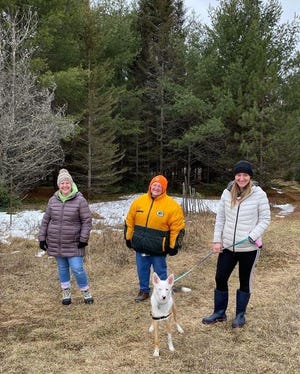 Rebecca, Susan, Rachel, and Joy the dog walking around the cabin property.