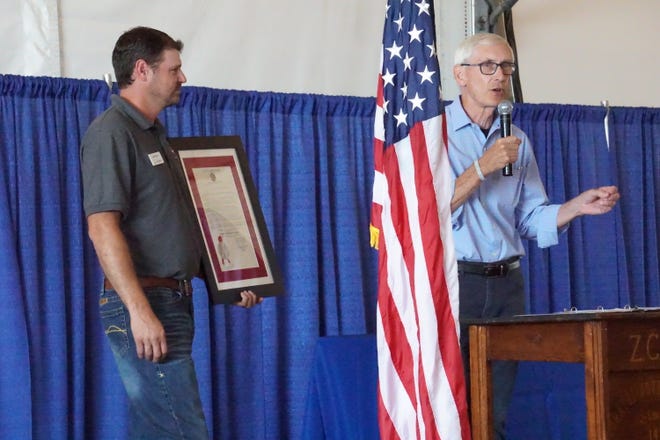 Gov. Evers presents executive committee chair Mike Gintner with a proclamation on the importance of Farm Technology Days returning to Wisconsin.