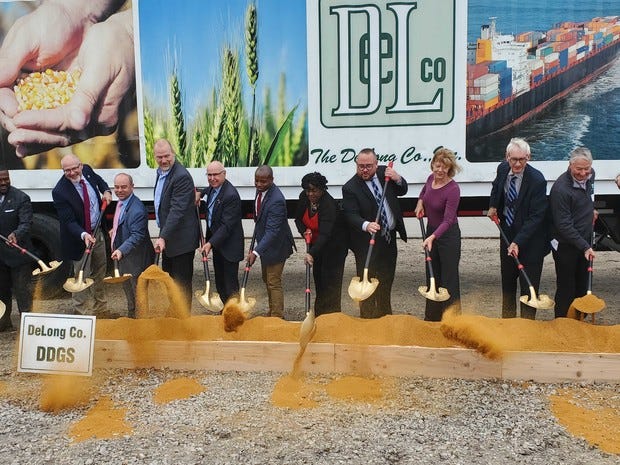 Officials "break ground" on Port Milwaukee's new DeLong Agricultural Maritime Export Facility on Wednesday. While construction has not yet started, the crew dug into a bin of dry distiller's grain, which will be one of the main exports from the new facility.