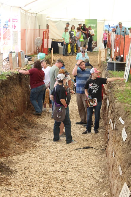 NRCS employees answer questions in the soil pit at Farm Technology Days in Clark County, July 12-14, 2022.