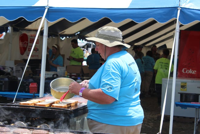 A volunteer butters the bread on these grilled sandwiches featuring colby cheese at Farm Technology Days in Clark County, July 12-14, 2022.